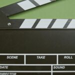 A classic film clapperboard on a green surface, essential for movie scenes.